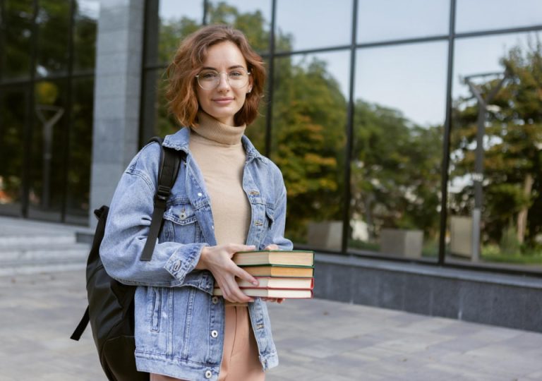 Φοιτήτρια πήρε φοιτητική άδεια από την εργασία της και ετοιμάζεται να δώσει εξετάσεις. Κρατά 4 βιβλία και κουβαλά μια τσάντα.